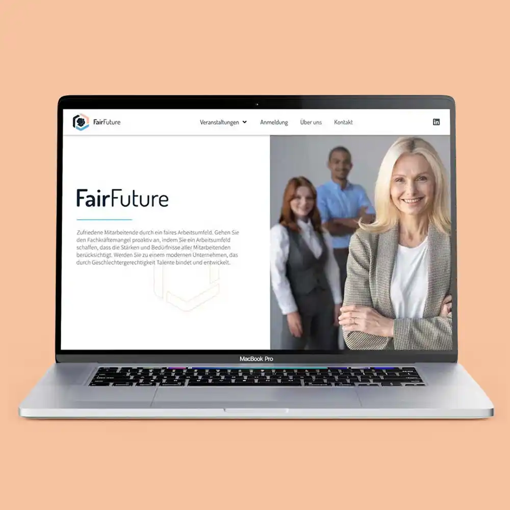 Startseite von Fairfuture auf einem Laptop mit Lachsfarbenem Hintergrund